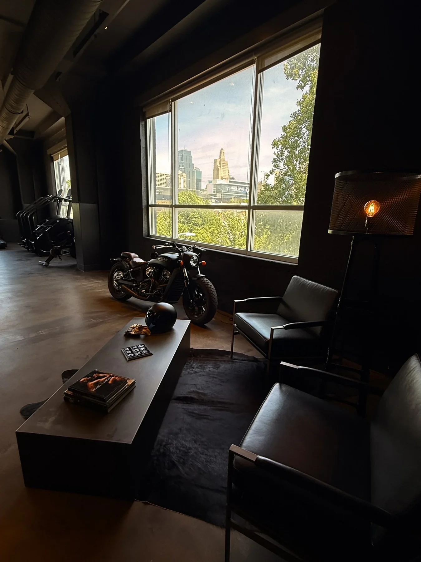Obsidian’s lounge with leather chairs, a motorcycle, and skyline views